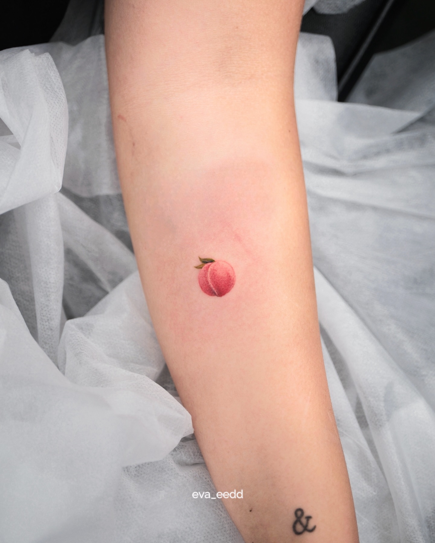 Peach realism tattoo on the forearm by Eva Liu