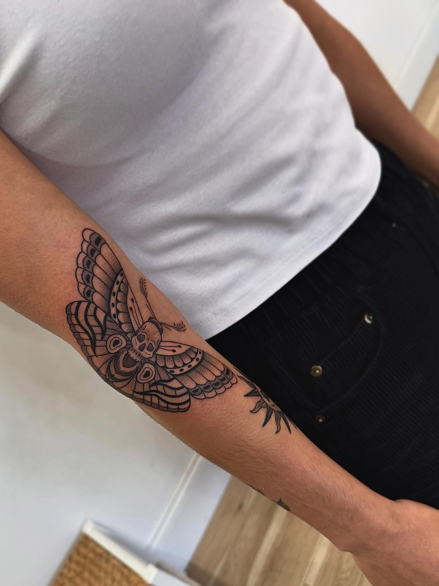 Moth black and grey tattoo on the forearm by Stefany
