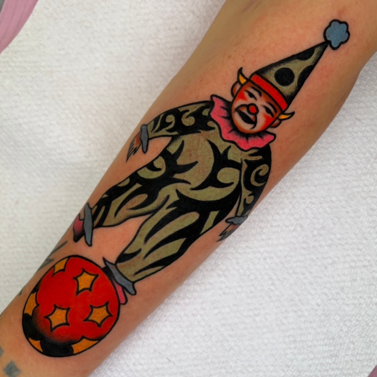Clown juggling ball American traditional tattoo on the forearm by rachael