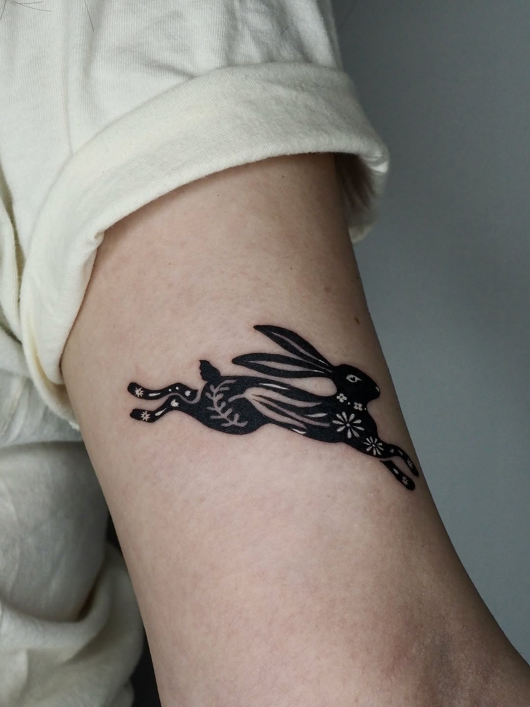 Running rabbit fine line tattoo on the forearm by A. Eye Tat