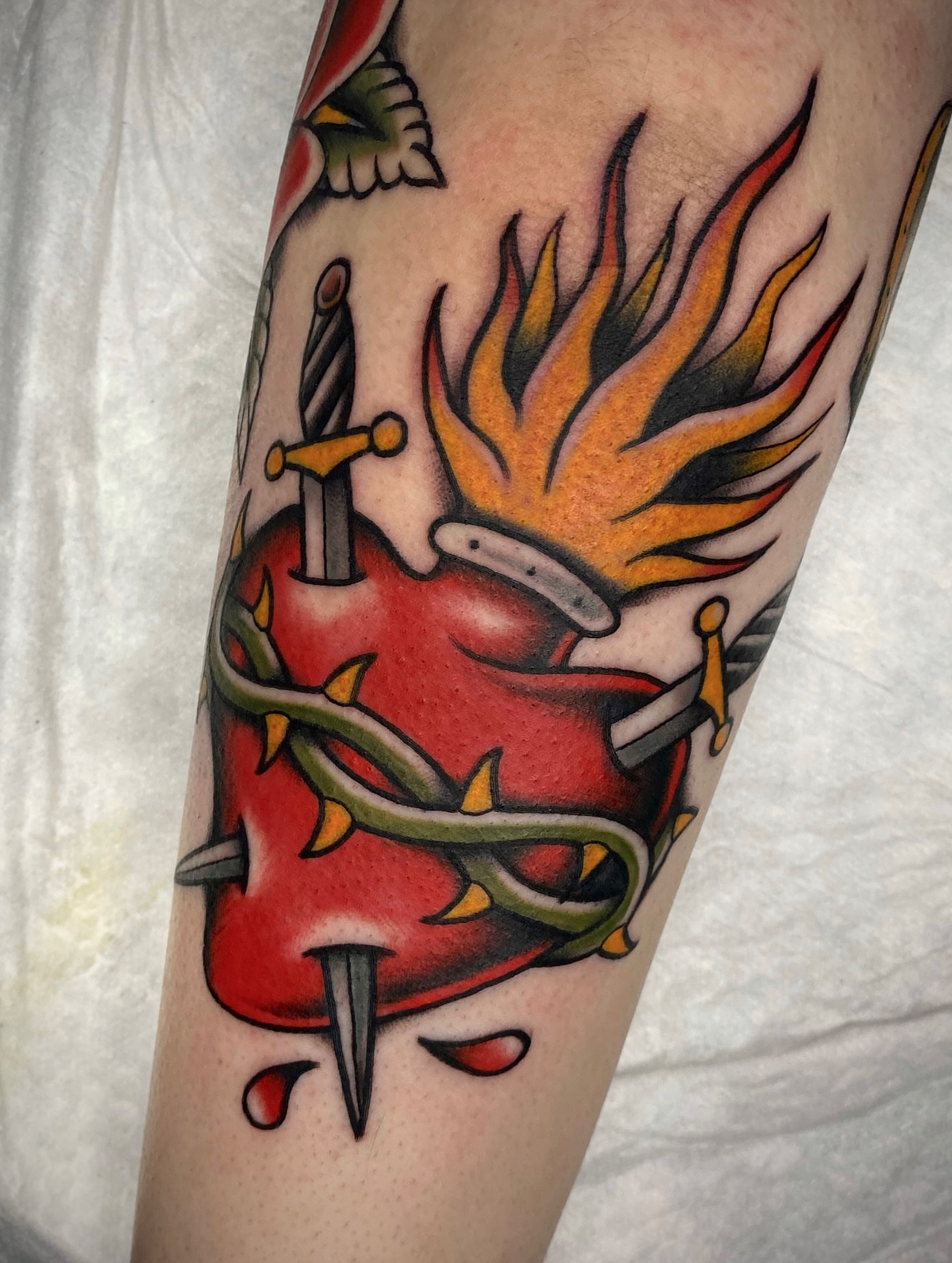 Heart with flames and sword American traditional tattoo on the forearm by Black and color tattoo!