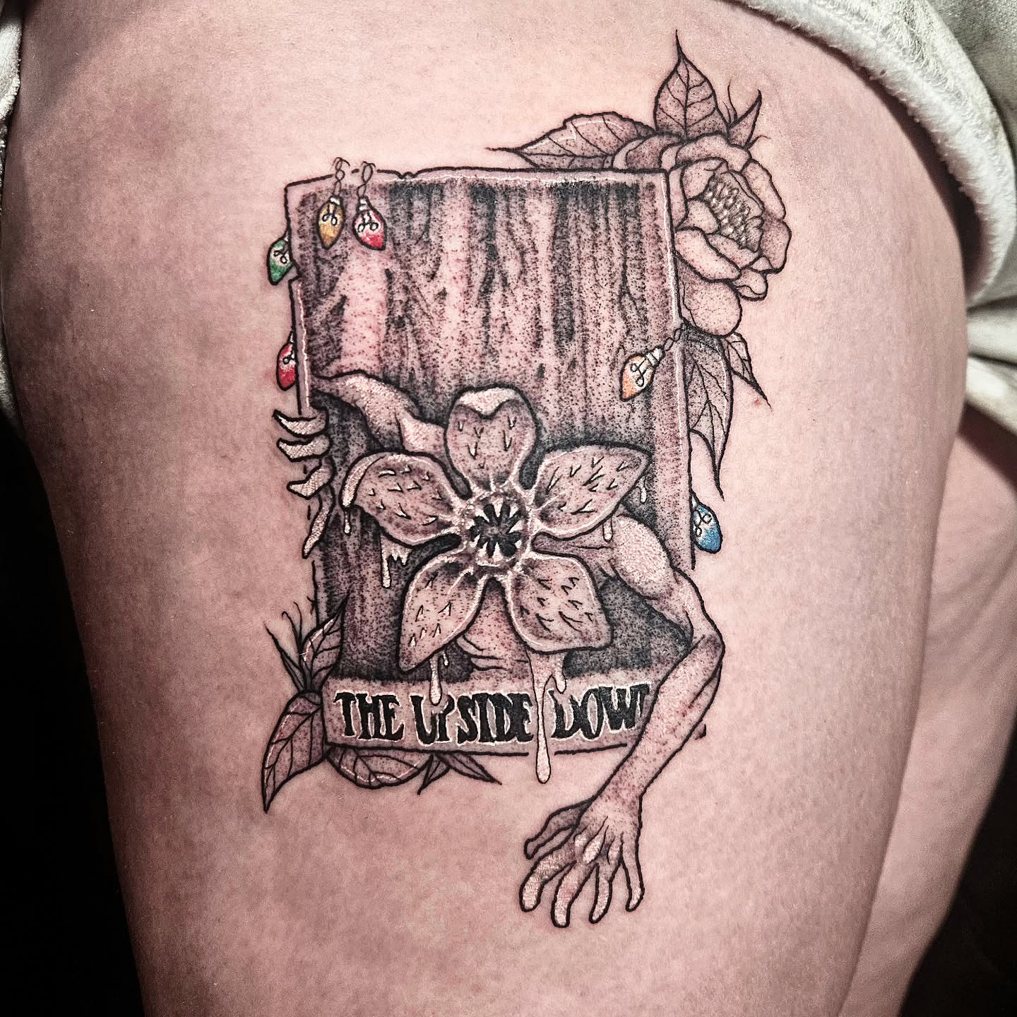Flower and creature dotwork tattoo on the thigh by Damian Eames