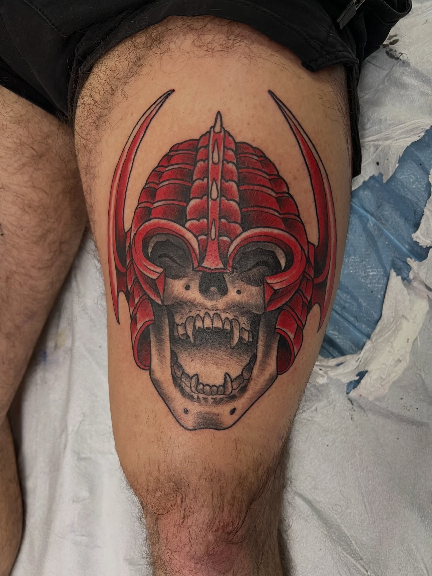 Skull with helmet dark realism tattoo on the thigh by Corey Thompson, Butler, Pennsylvania