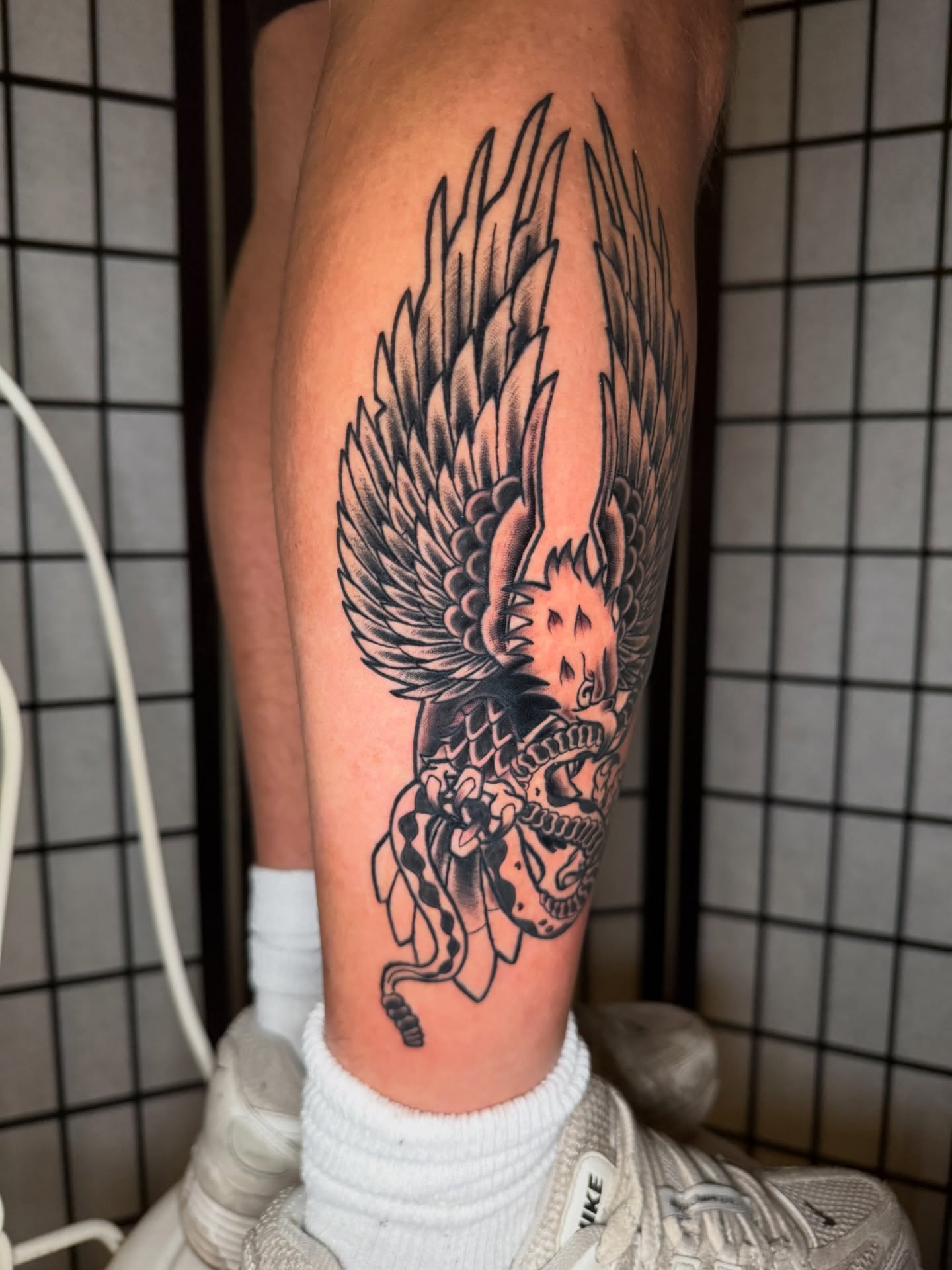 Winged dragon black and grey tattoo on the calf by Austin Poliszuk, Minneapolis, Minnesota