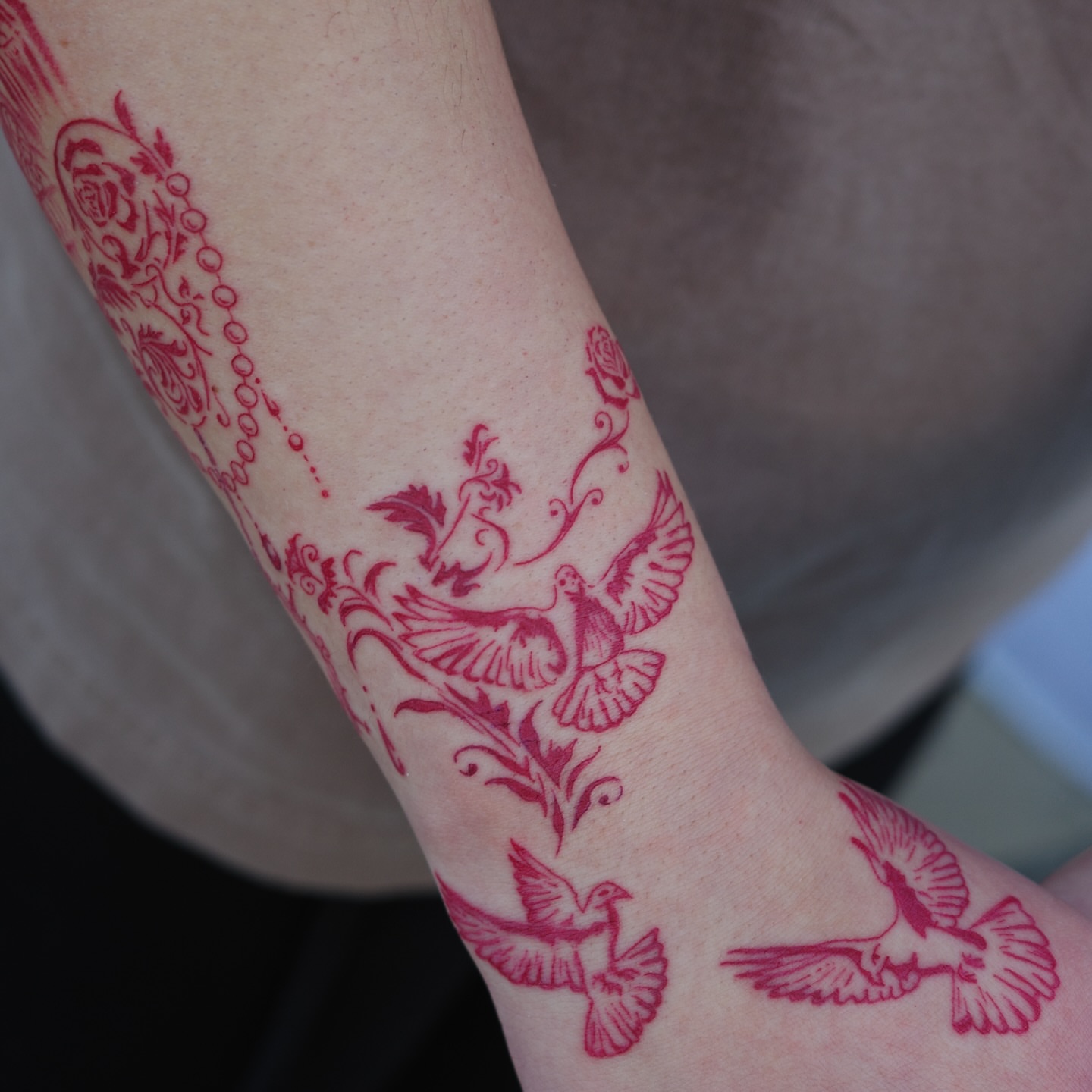 Doves and floral patterns neo-traditional tattoo on the forearm by Sophia Tattoo