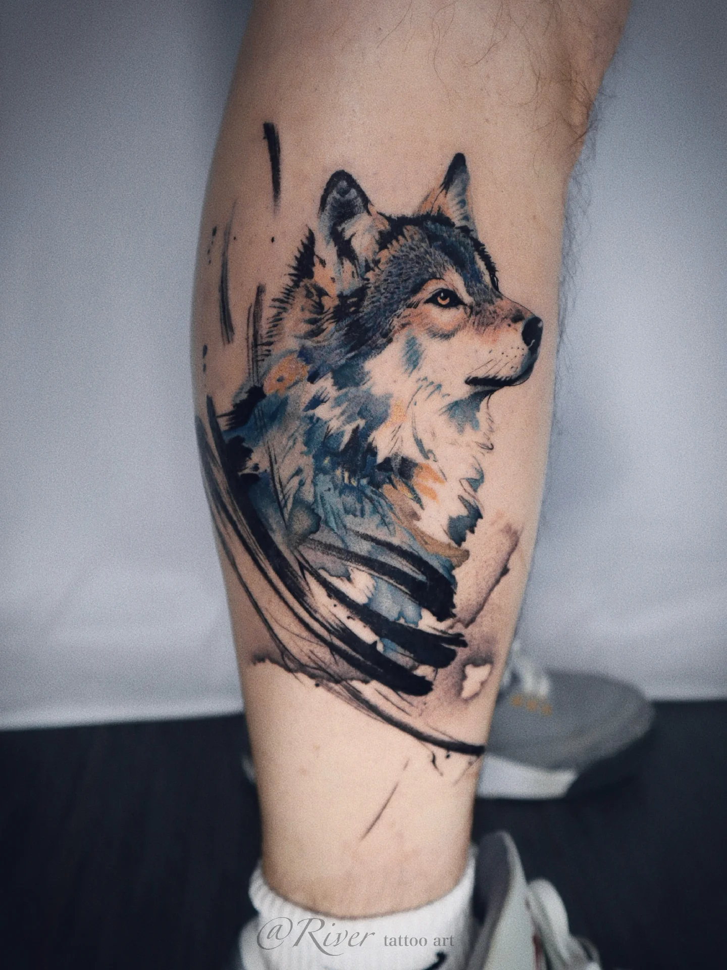 Wolf watercolor tattoo on the forearm by River