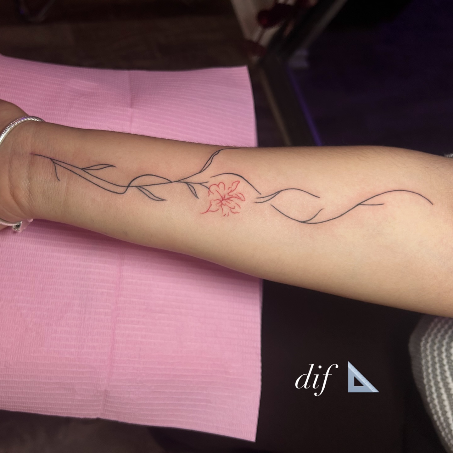 Flower branch fine line tattoo on the forearm by @tattoosbyskyeee