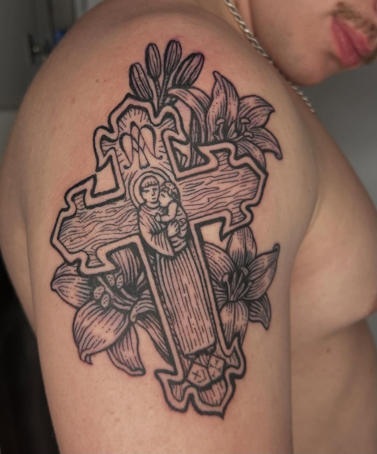 Religious cross with Madonna and Child black and grey tattoo on the shoulder by Jason Middelton