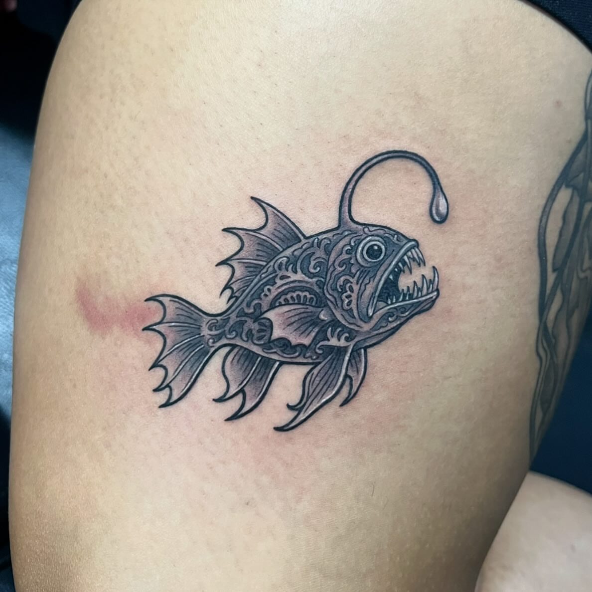 Angler fish black and grey tattoo on the thigh by Jay