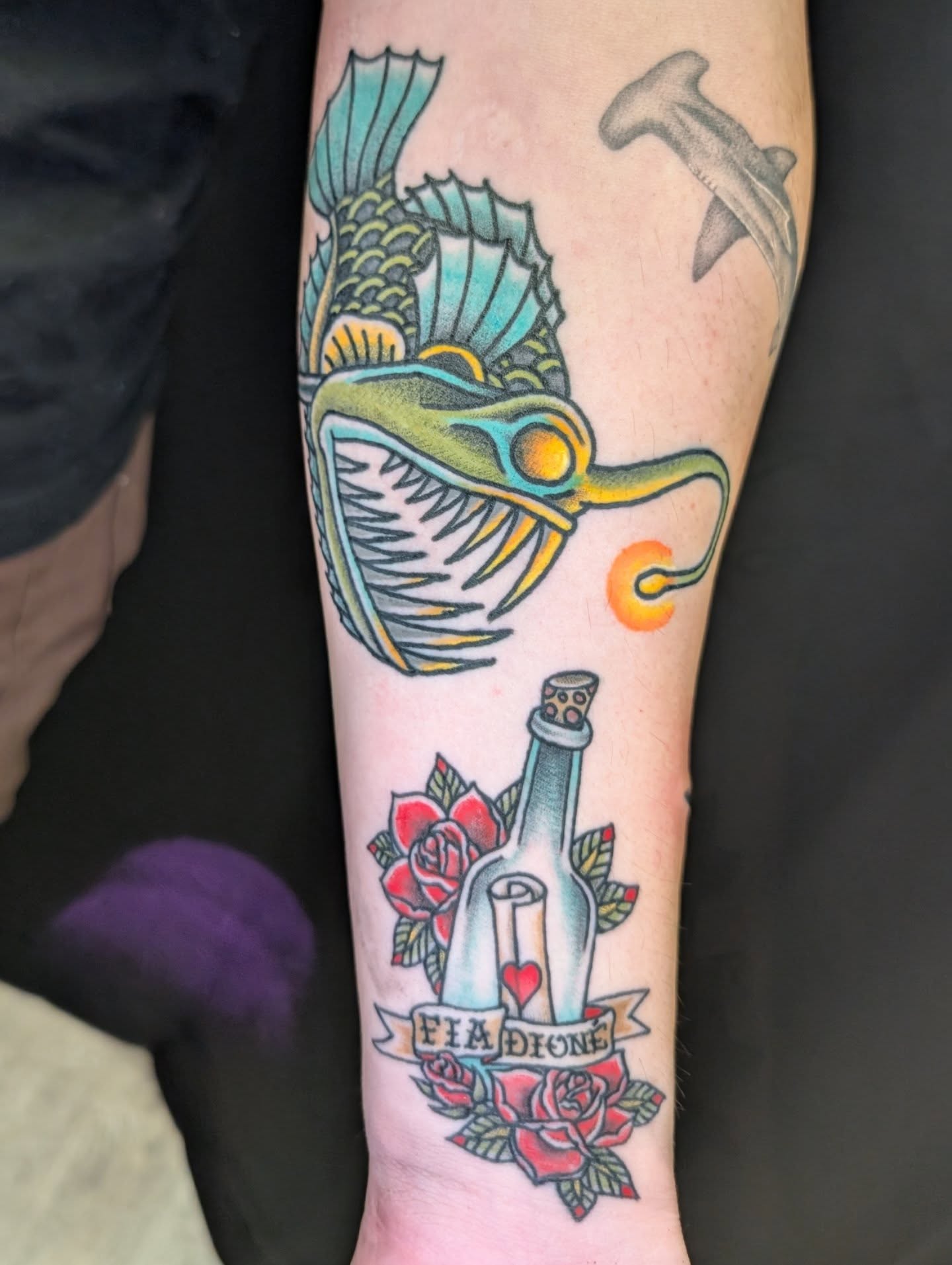 Angler fish and bottle American traditional tattoo on the forearm by Erik O'Steen, Medford, Massachusetts