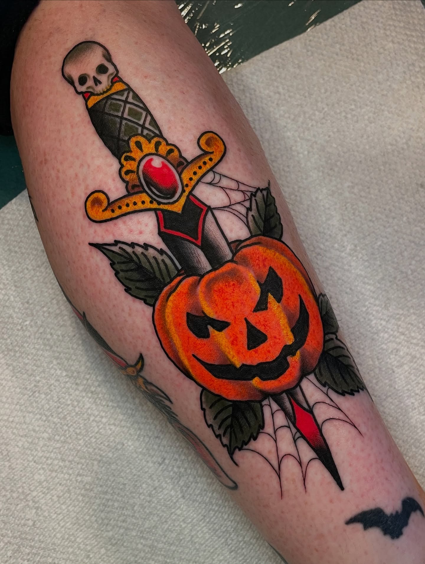 Pumpkin and dagger American traditional tattoo on the forearm by Ian Spong
