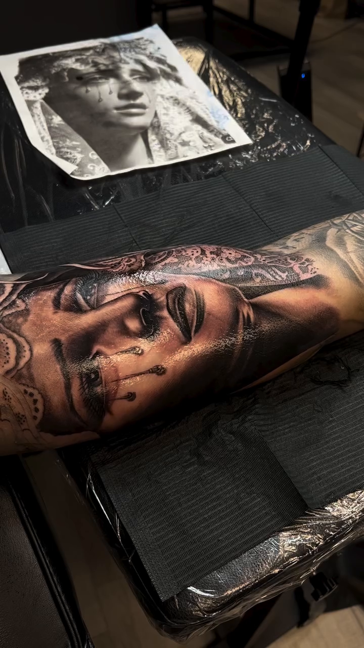 Portrait of a woman realism tattoo on the upper arm by Hugo Ruiz-Esparza