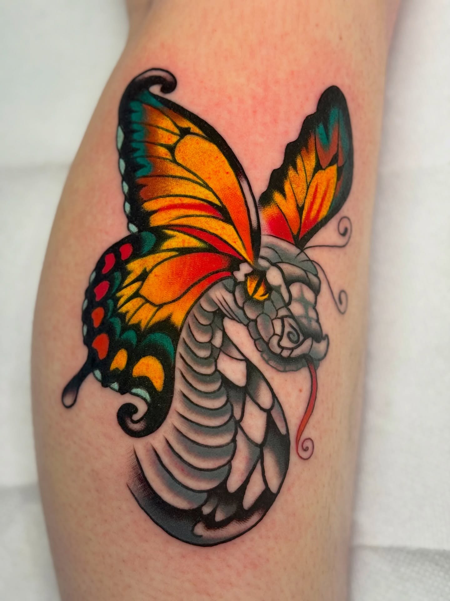 Butterfly and snake American traditional tattoo on the thigh by sydtatz