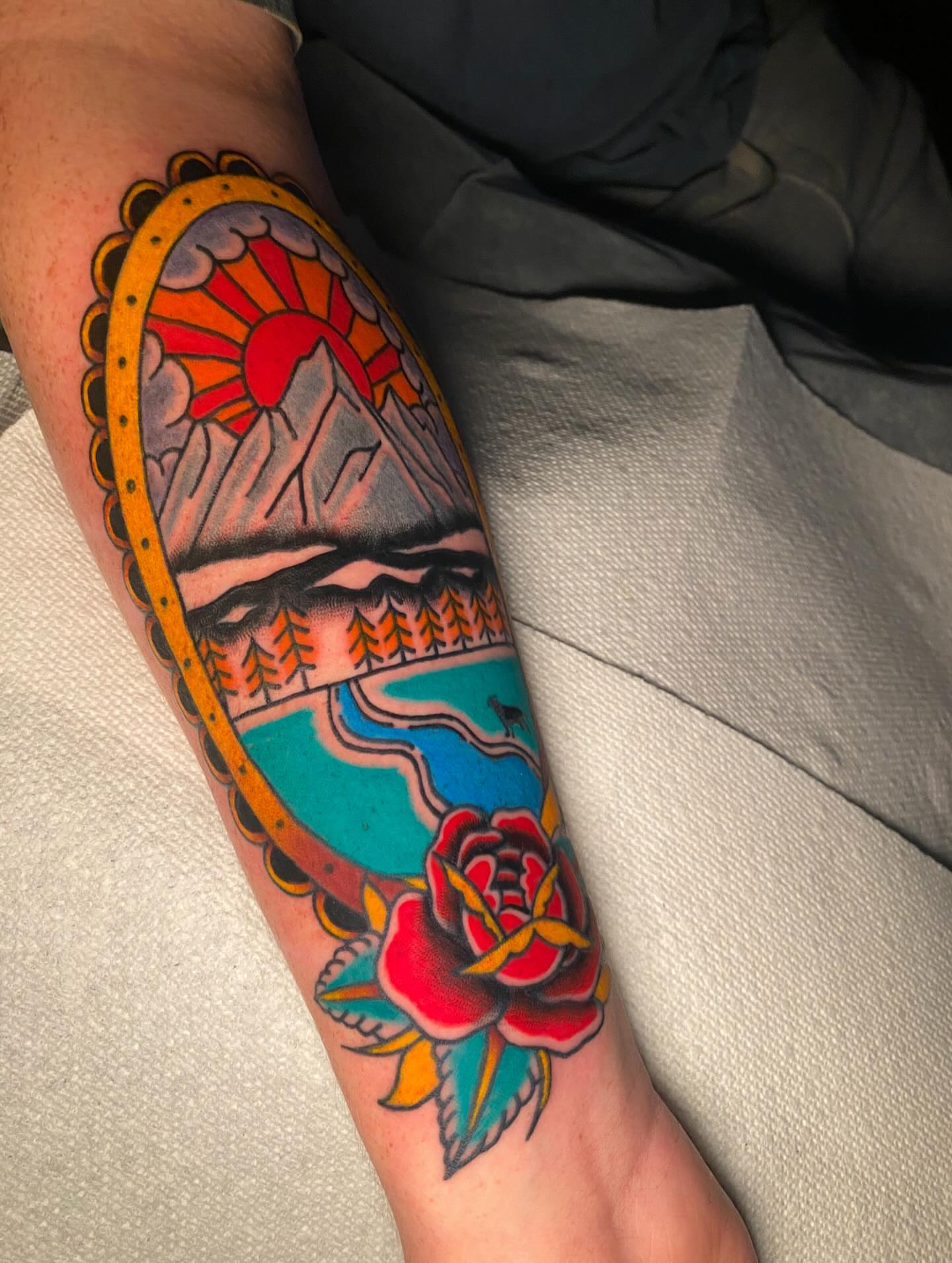 Landscape with rose American traditional tattoo on the forearm by Nosferatu