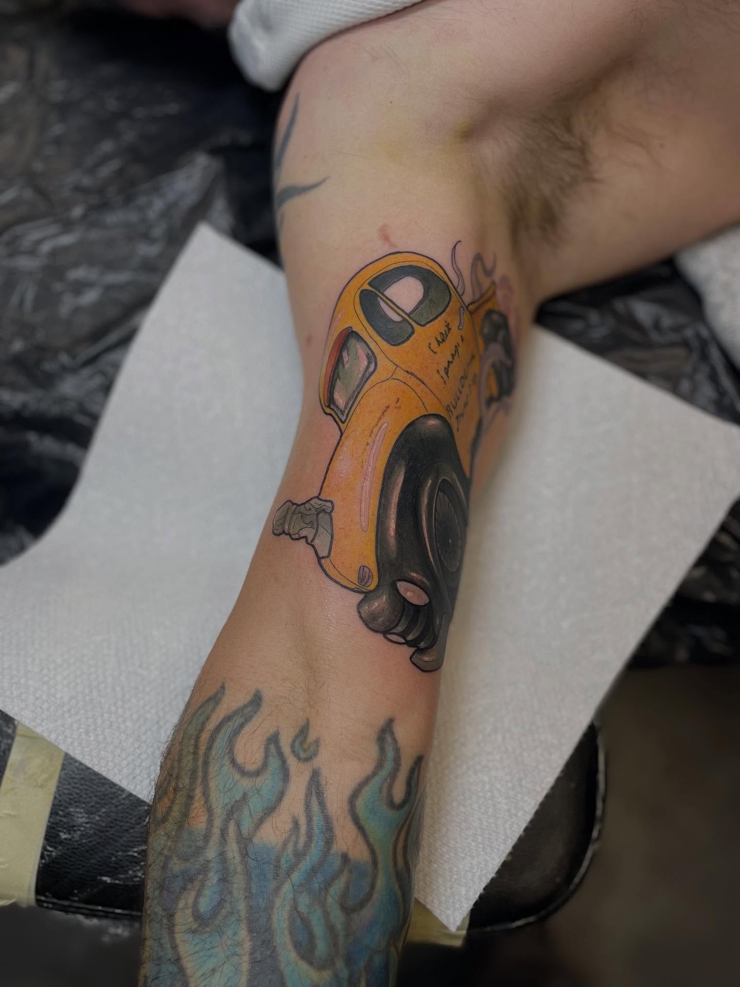 Yellow car realism tattoo on the forearm by Nathan Evans