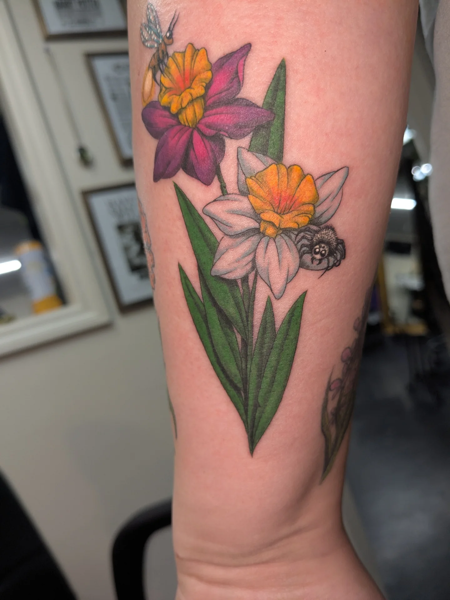 Daffodils and bee realism tattoo on the forearm by Jessica Thomas Fleischman, Morganton, North Carolina