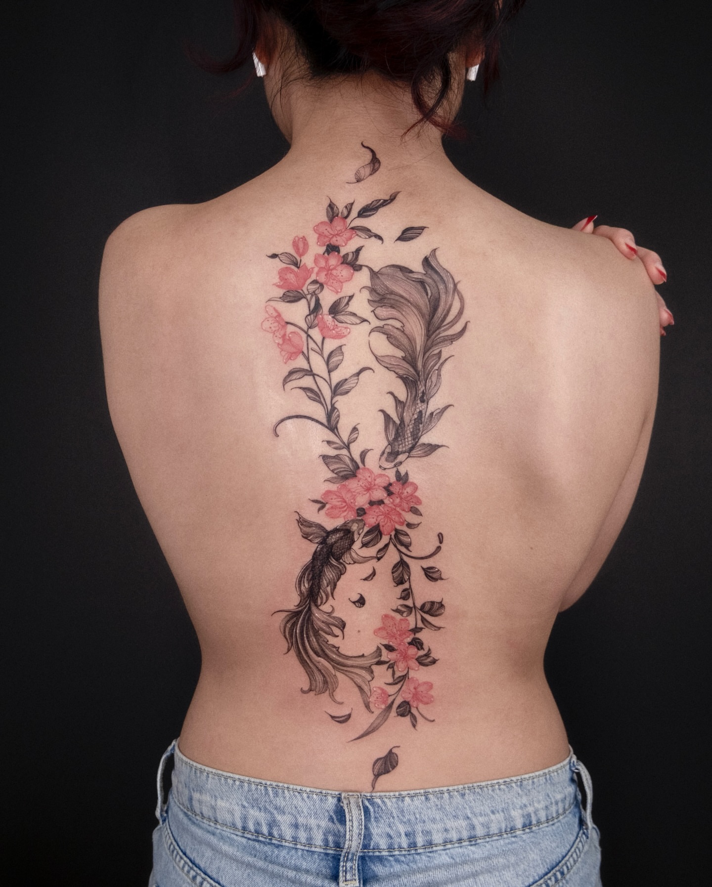 Flower and feather black and grey tattoo on the back by Wong Lee