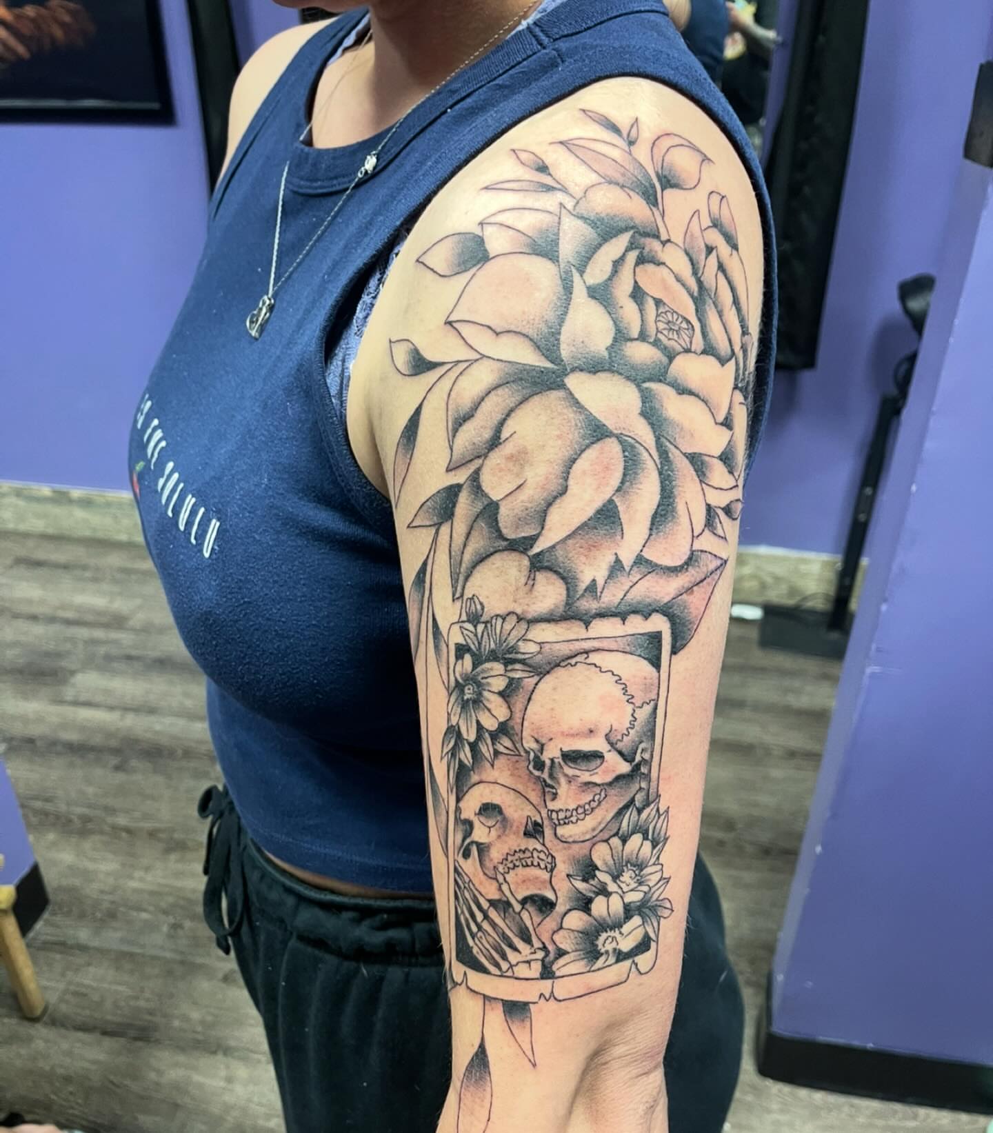 Skulls and flowers black and grey tattoo on the forearm by Mark Calloway