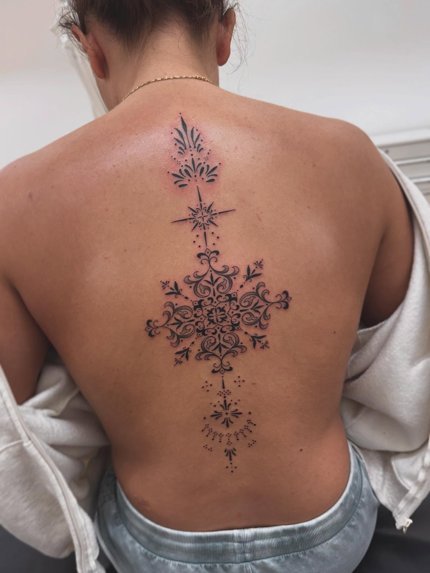 Snowflake dotwork tattoo on the back by Stefany