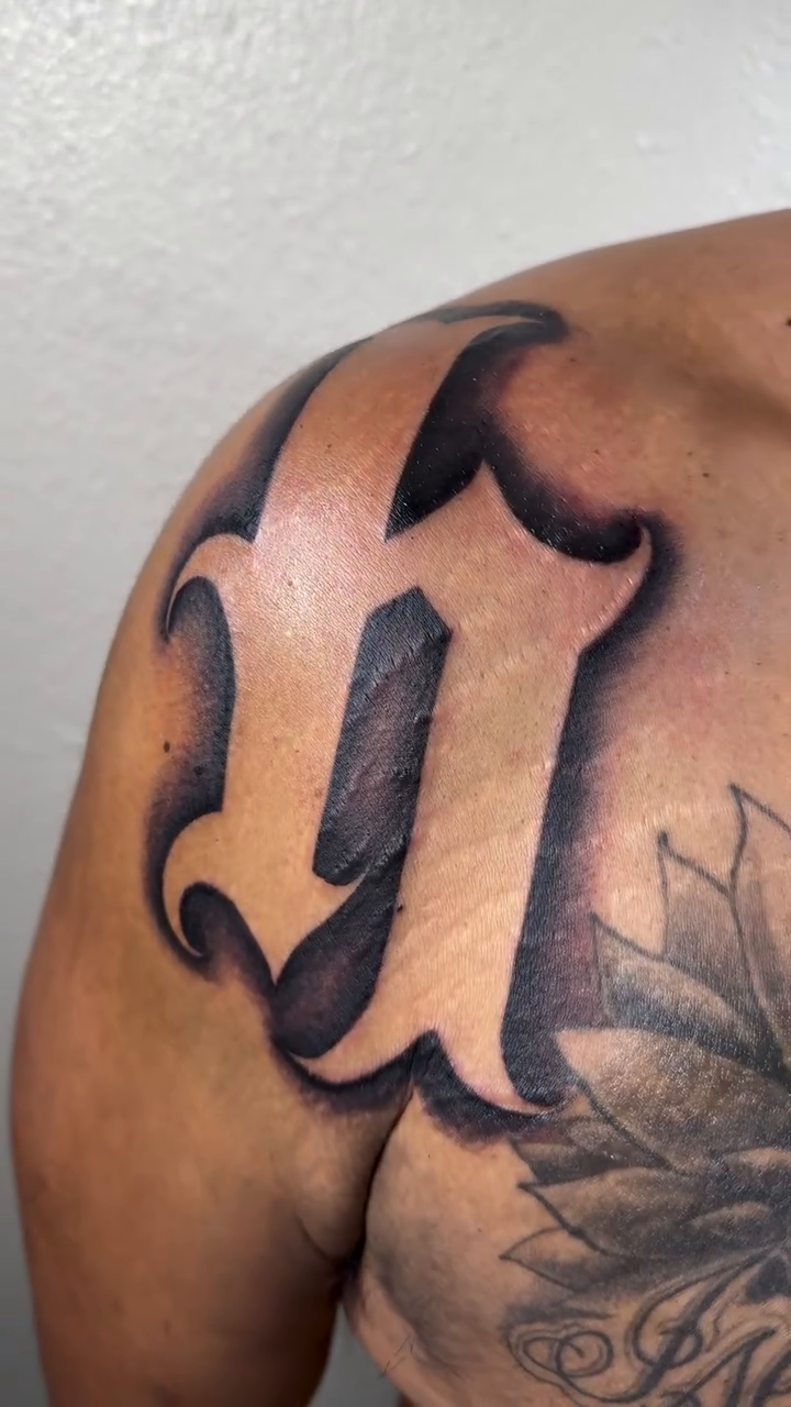 The letter 'U' lettering script tattoo by Daniel Lopez Tattoos