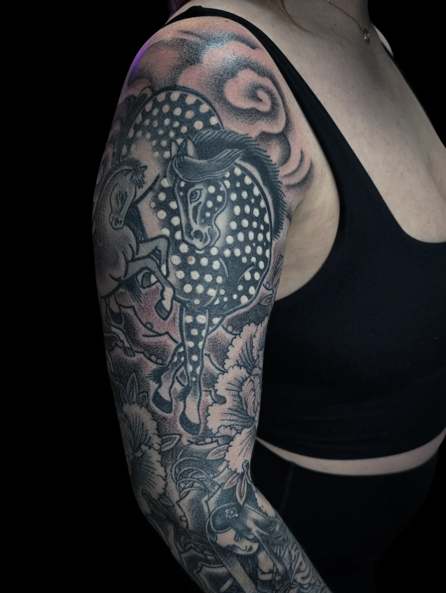 Horse and polka dots dotwork tattoo on the upper arm by Angela Mukai