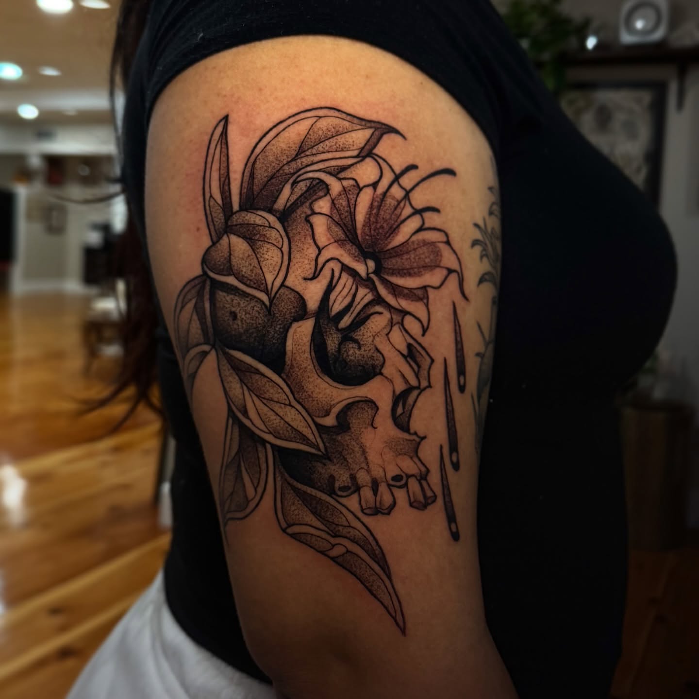 Skull and flower dotwork tattoo on the forearm by Lauren Peltz