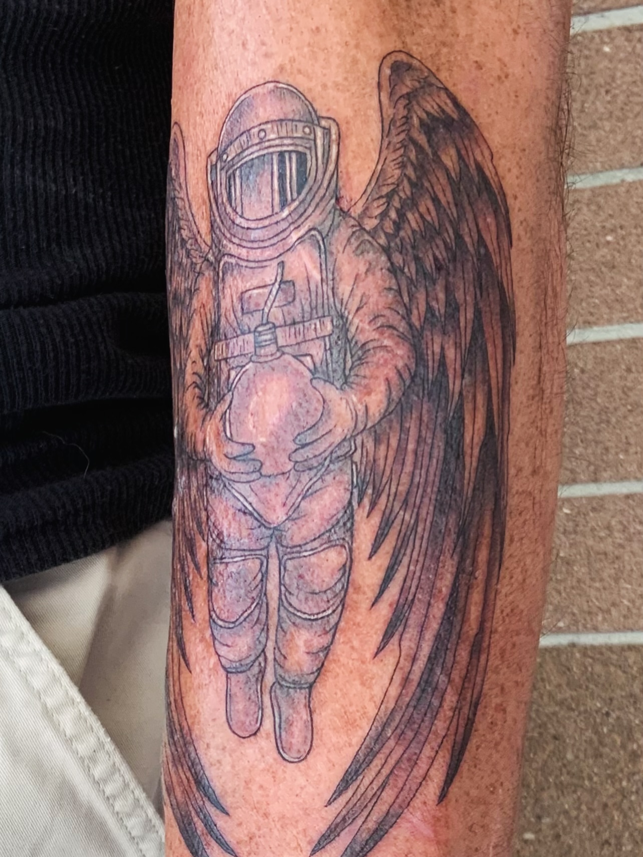 Astronaut with wings realism tattoo on the forearm by QUEEN TATTOO Stephanie Larson
