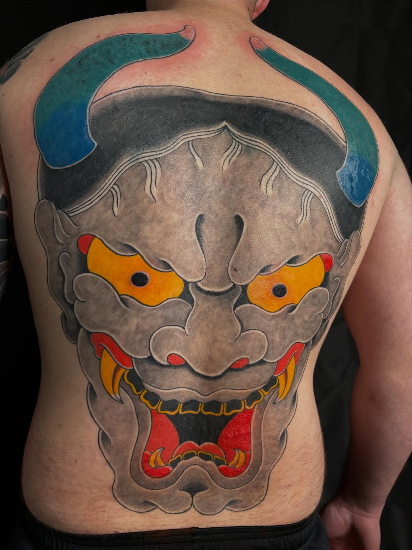 Demon mask American traditional tattoo on the back by Zach Hendrickson