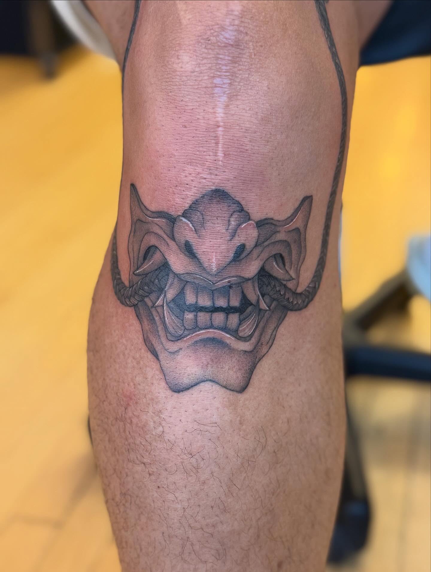 Demon mask black and grey tattoo on the forearm by Dre