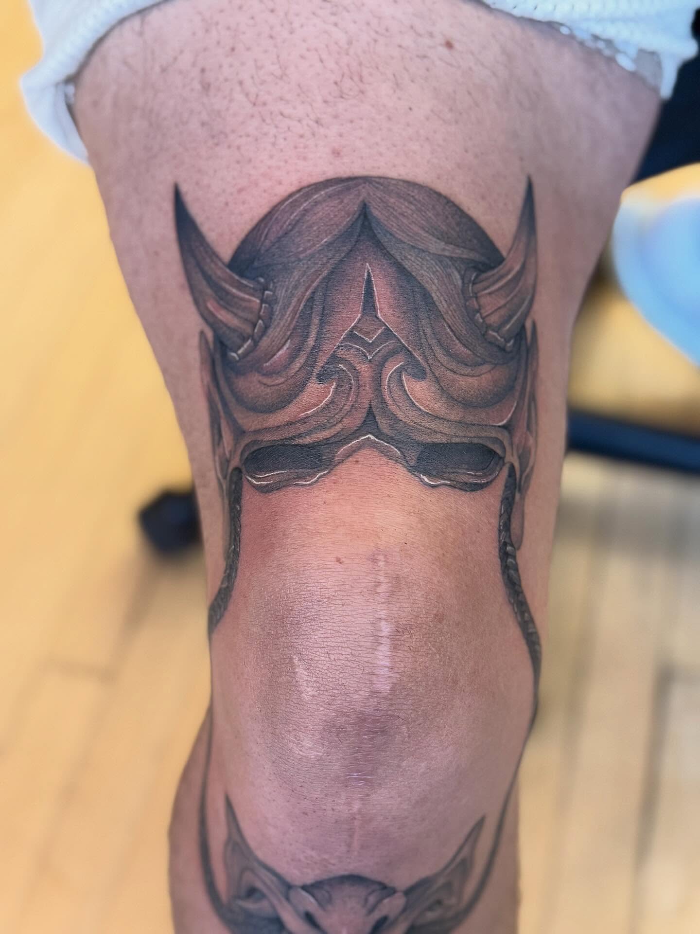 Mask black and grey tattoo on the thigh by Dre