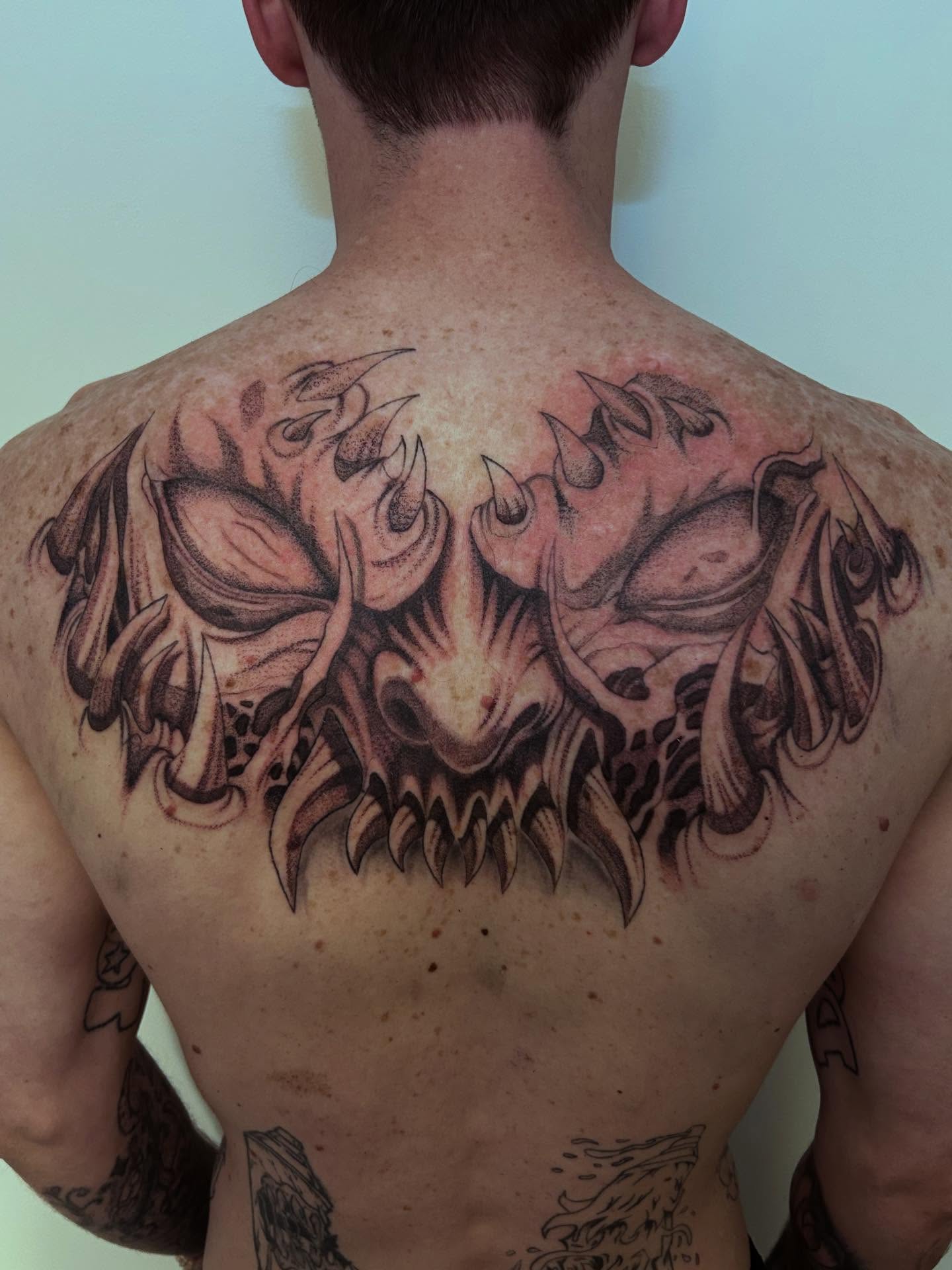Demon skull dark realism tattoo on the back by Chris