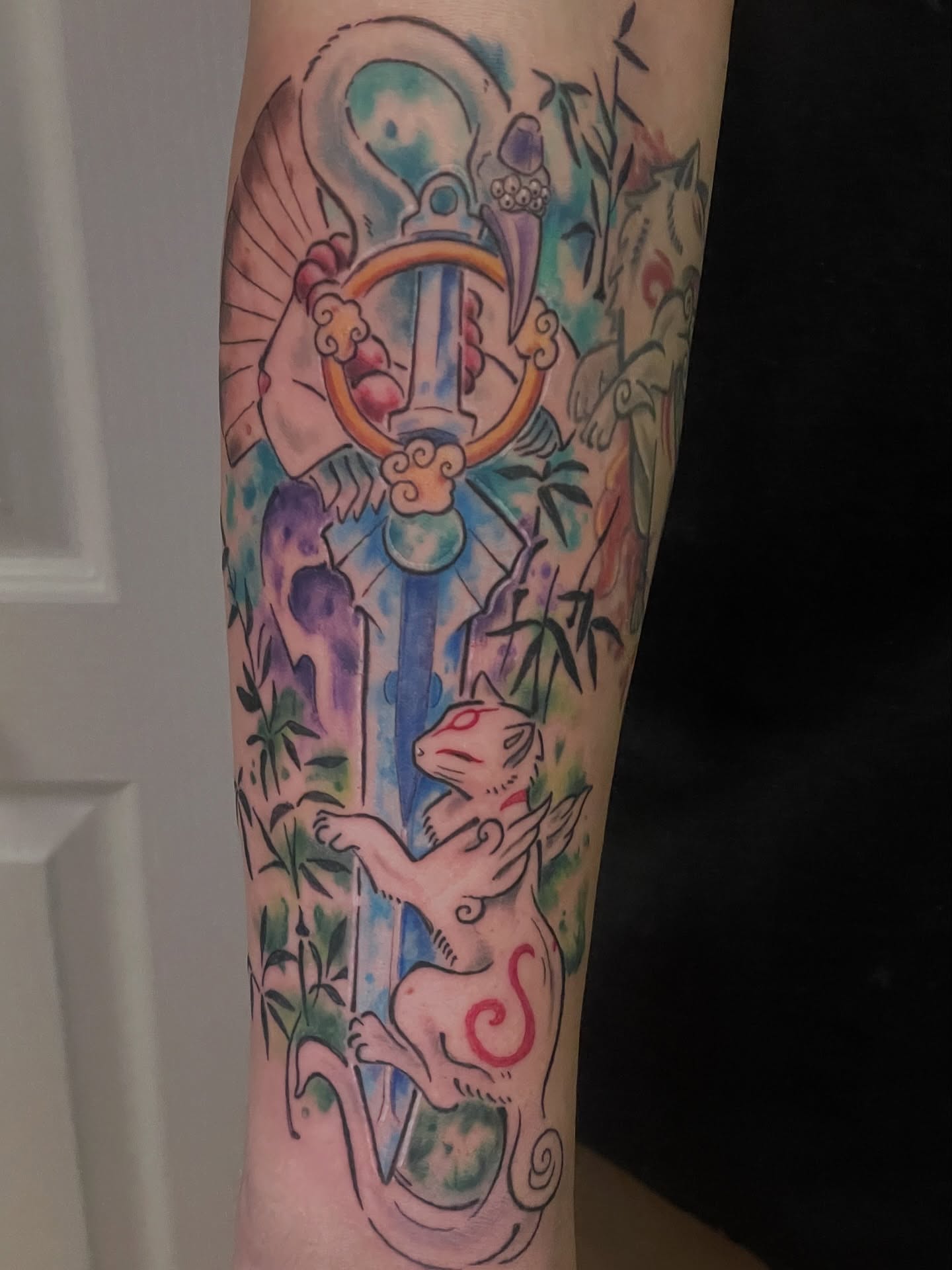 Cat and sword watercolor tattoo on the forearm by 𝑲𝒂𝒊𝒕 𝑨𝒏𝒅𝒆𝒓𝒔𝒆𝒏