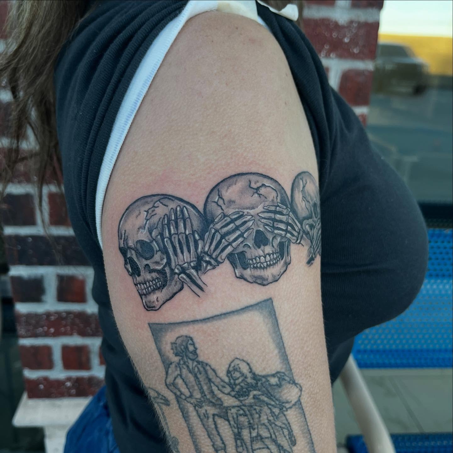 Skulls and religious scene realism tattoo on the shoulder by Lexi Odam