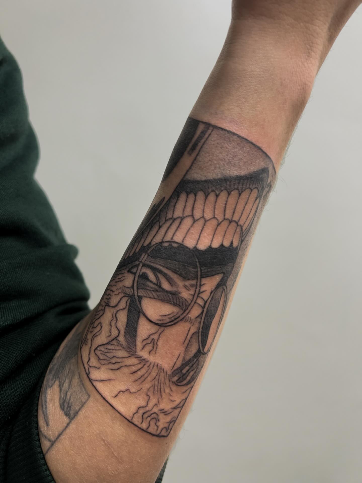 Mask black and grey tattoo on the forearm by Diana García