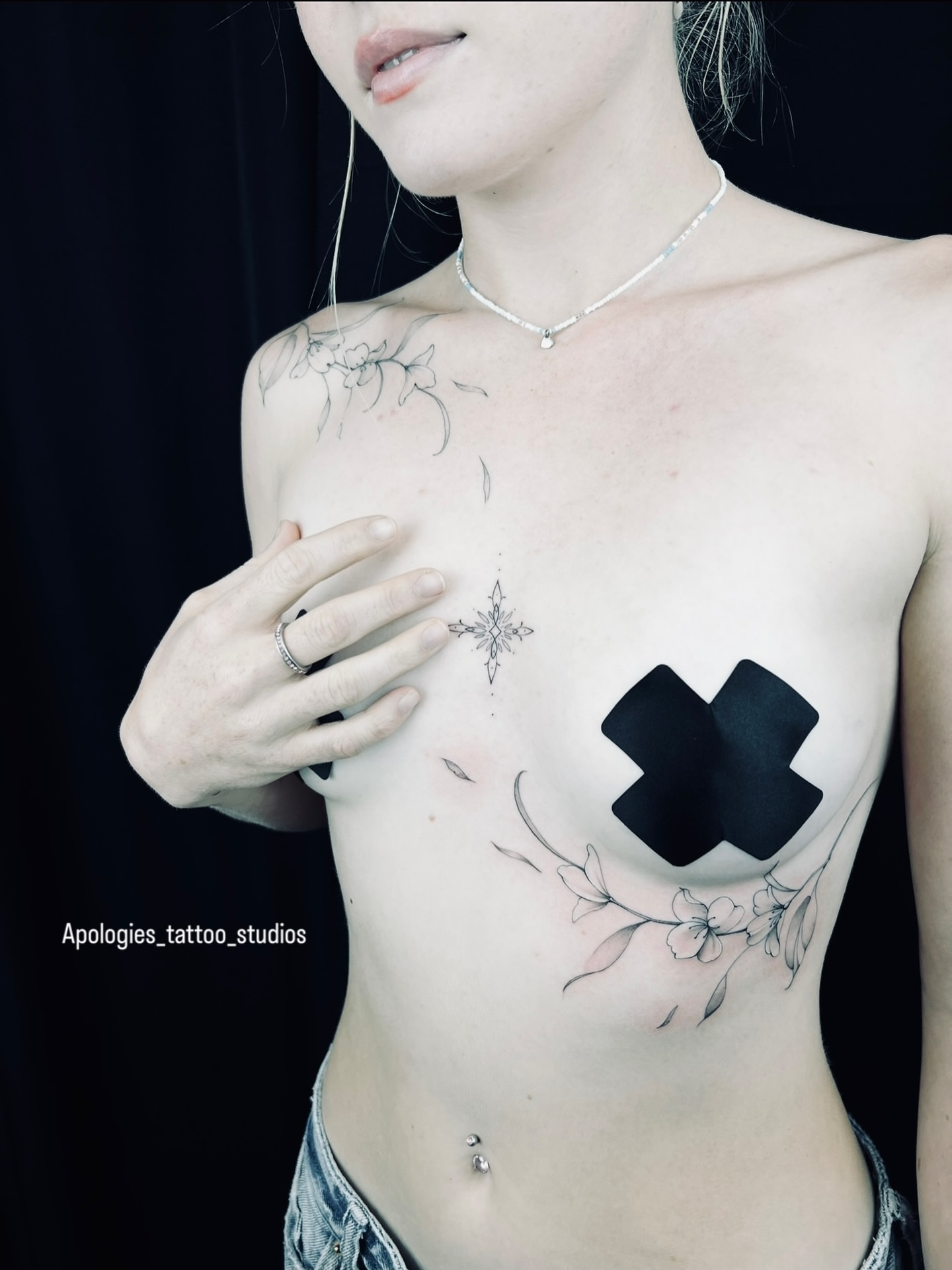 Cross black and grey tattoo on the chest by Apologies tattoo studios.
