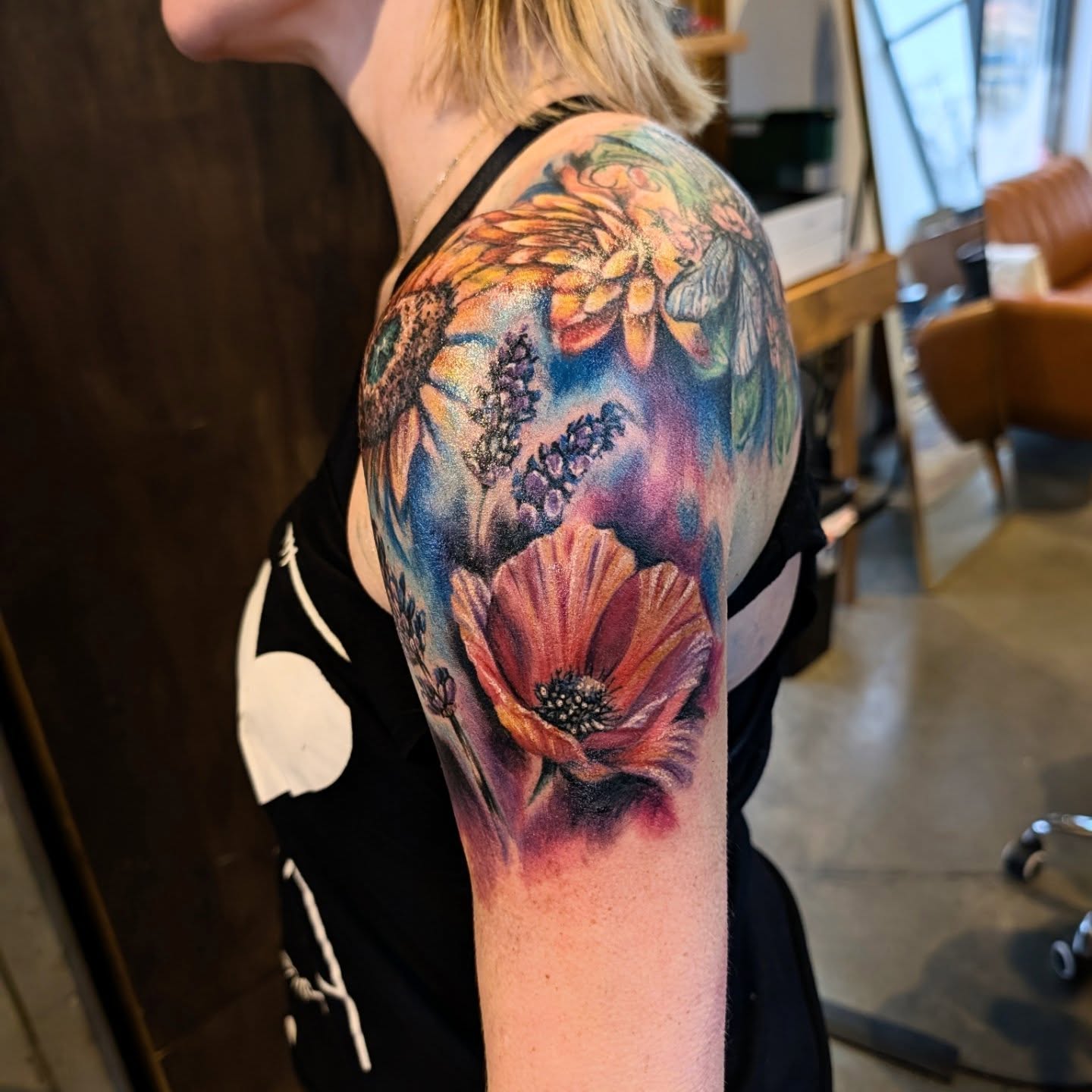 Flower bouquet watercolor tattoo on the upper arm by Drew King