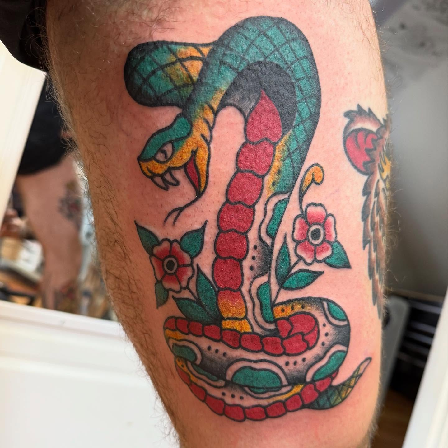 Snake and flowers American traditional tattoo on the forearm by Tony Beuke