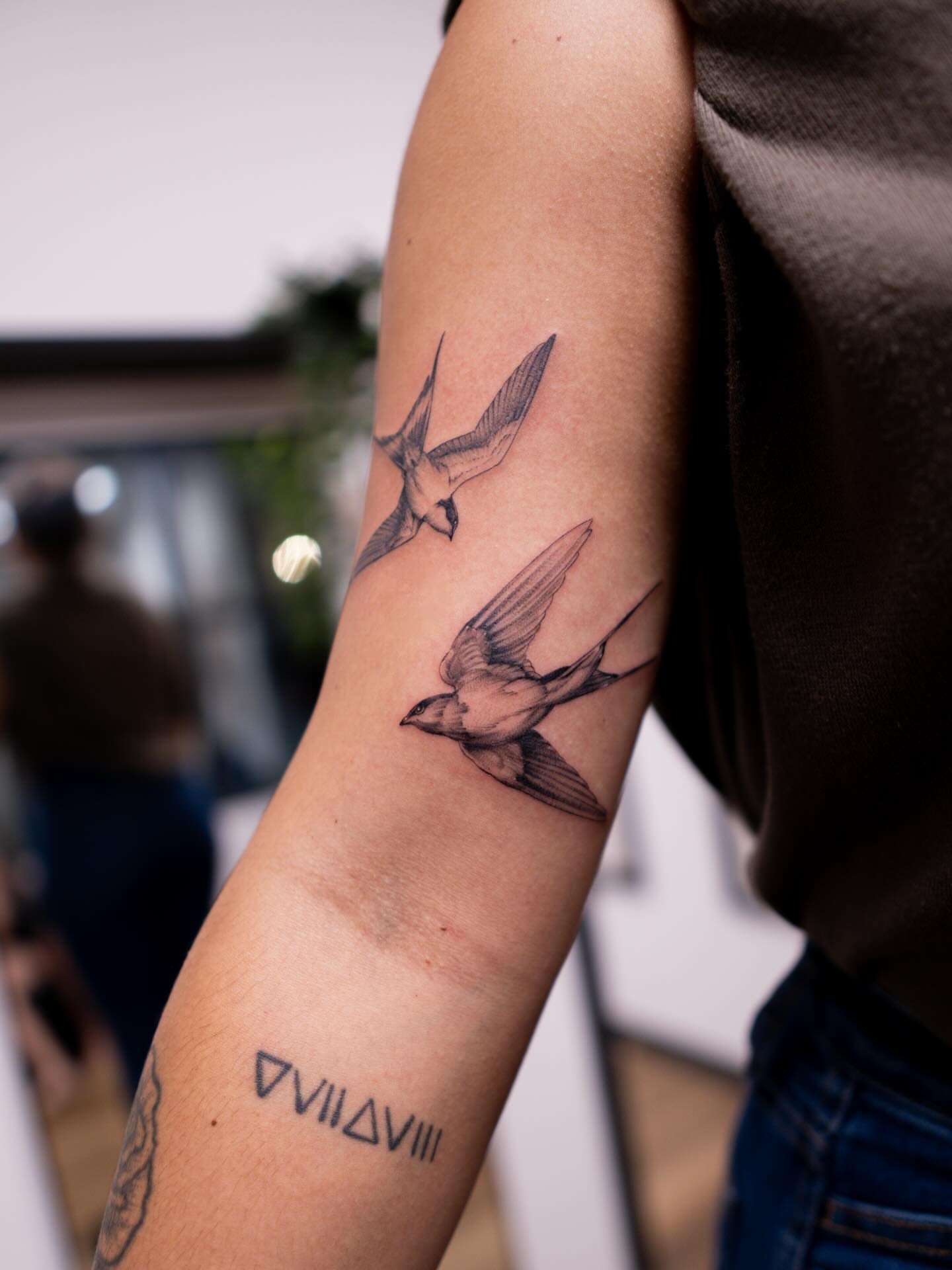 Swallows black and grey tattoo on the forearm by Adriano Bassalo
