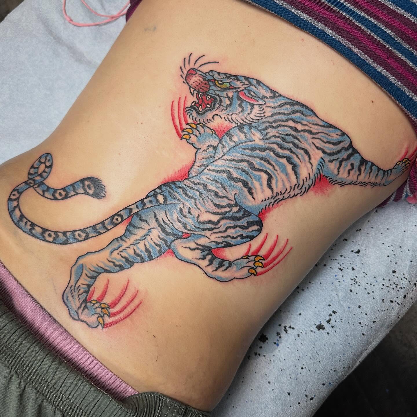 Tiger American traditional tattoo on the ribs by Devin Spenny