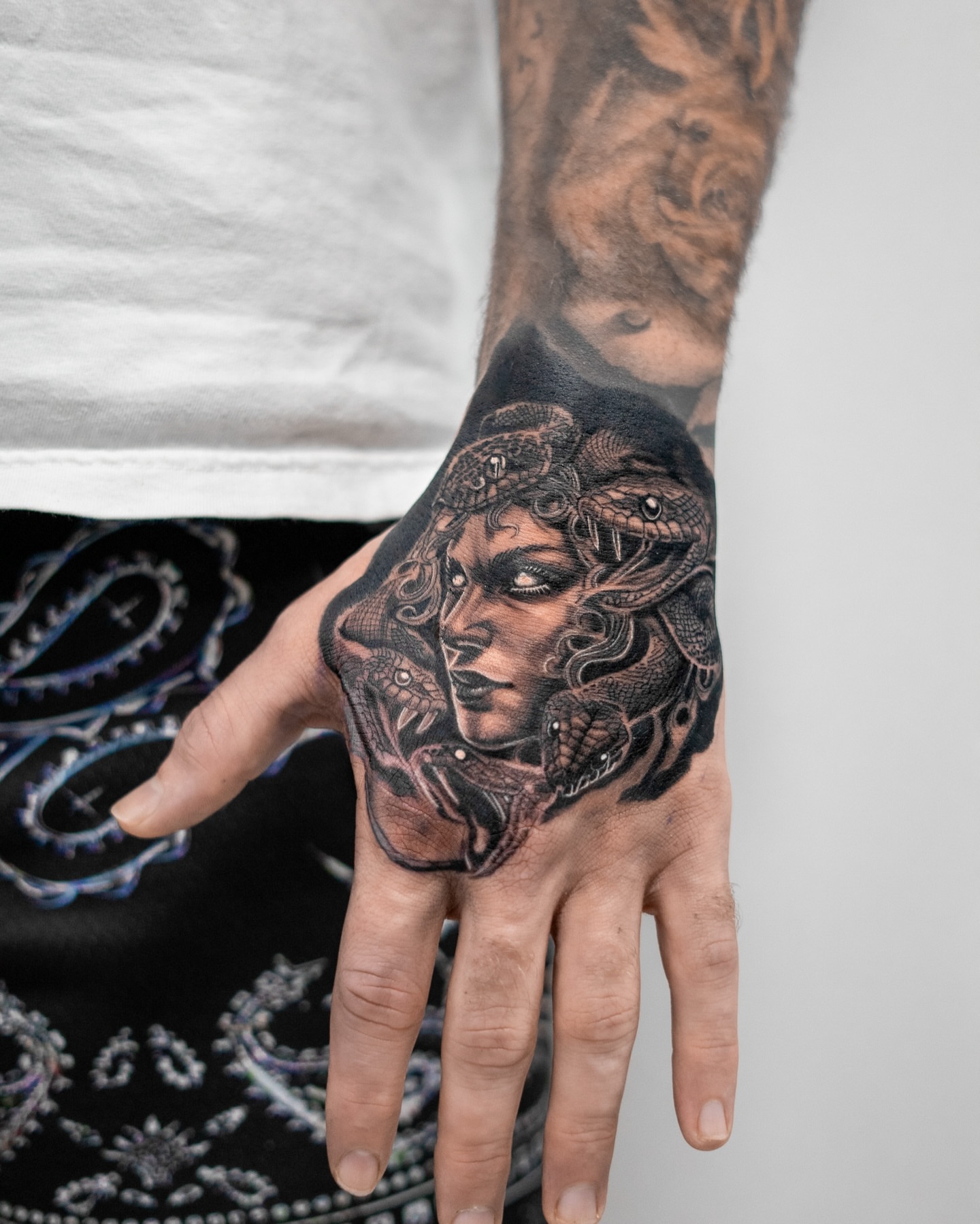 Woman with snakes realism tattoo on the hand by The Tattoo Plug