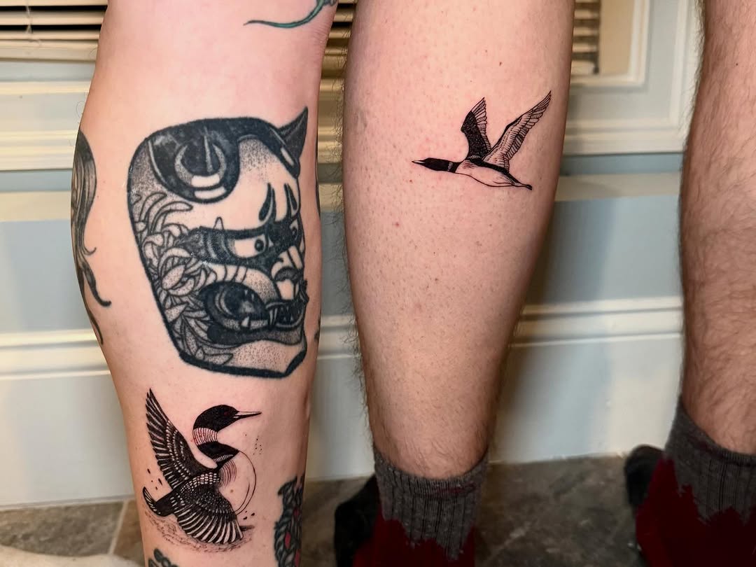 Demon mask and loons sketch tattoo on the leg by Ana Blatt