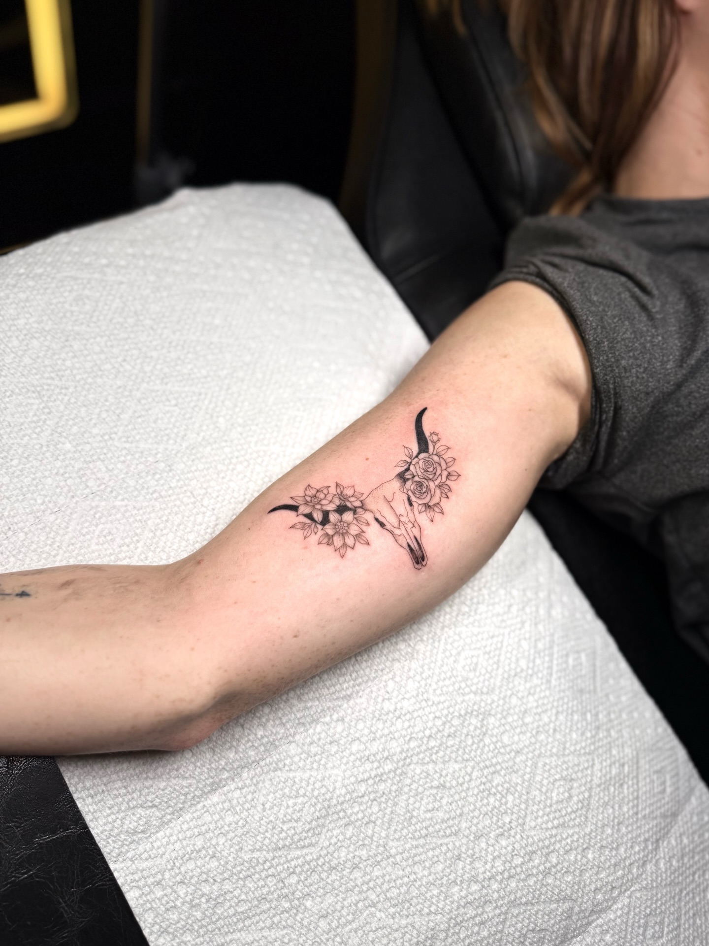 Skull and flowers black and grey tattoo on the forearm by ꜰɪɴᴇ ʟɪɴᴇ ᴛᴀᴛᴛᴏᴏꜱ