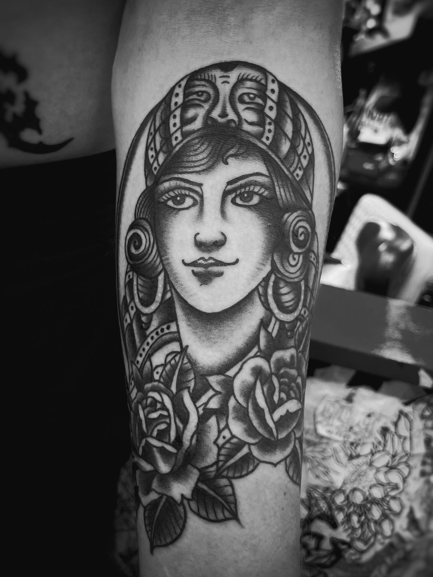 Woman with roses American traditional tattoo on the forearm by Gilbert Gonzalez
