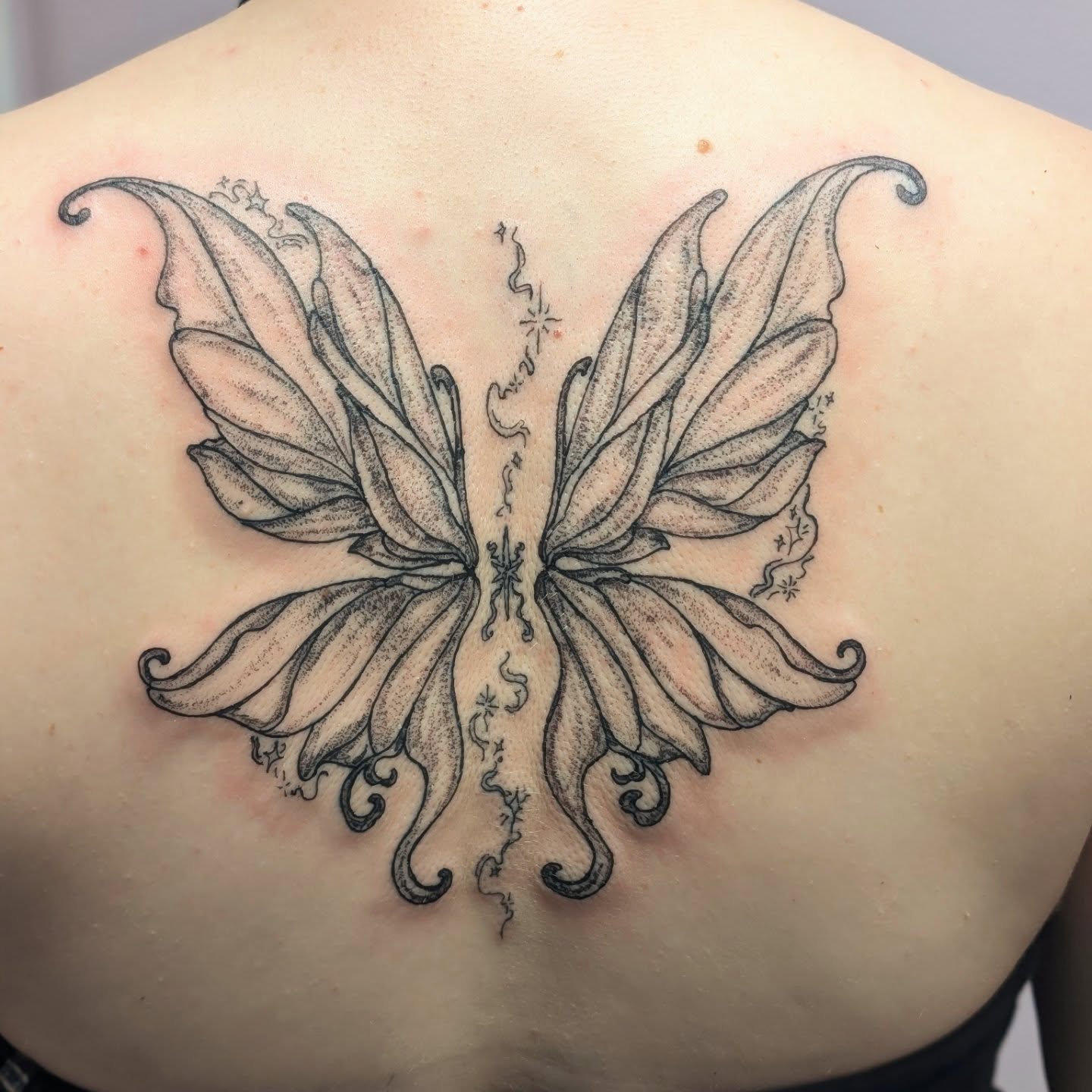 Butterfly wings black and grey tattoo on the back by Ryan