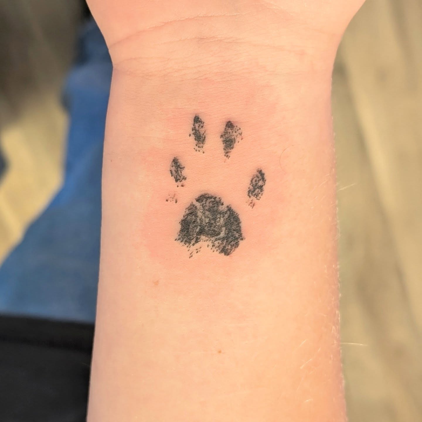 Dog paw print dotwork tattoo on the forearm by Ryan