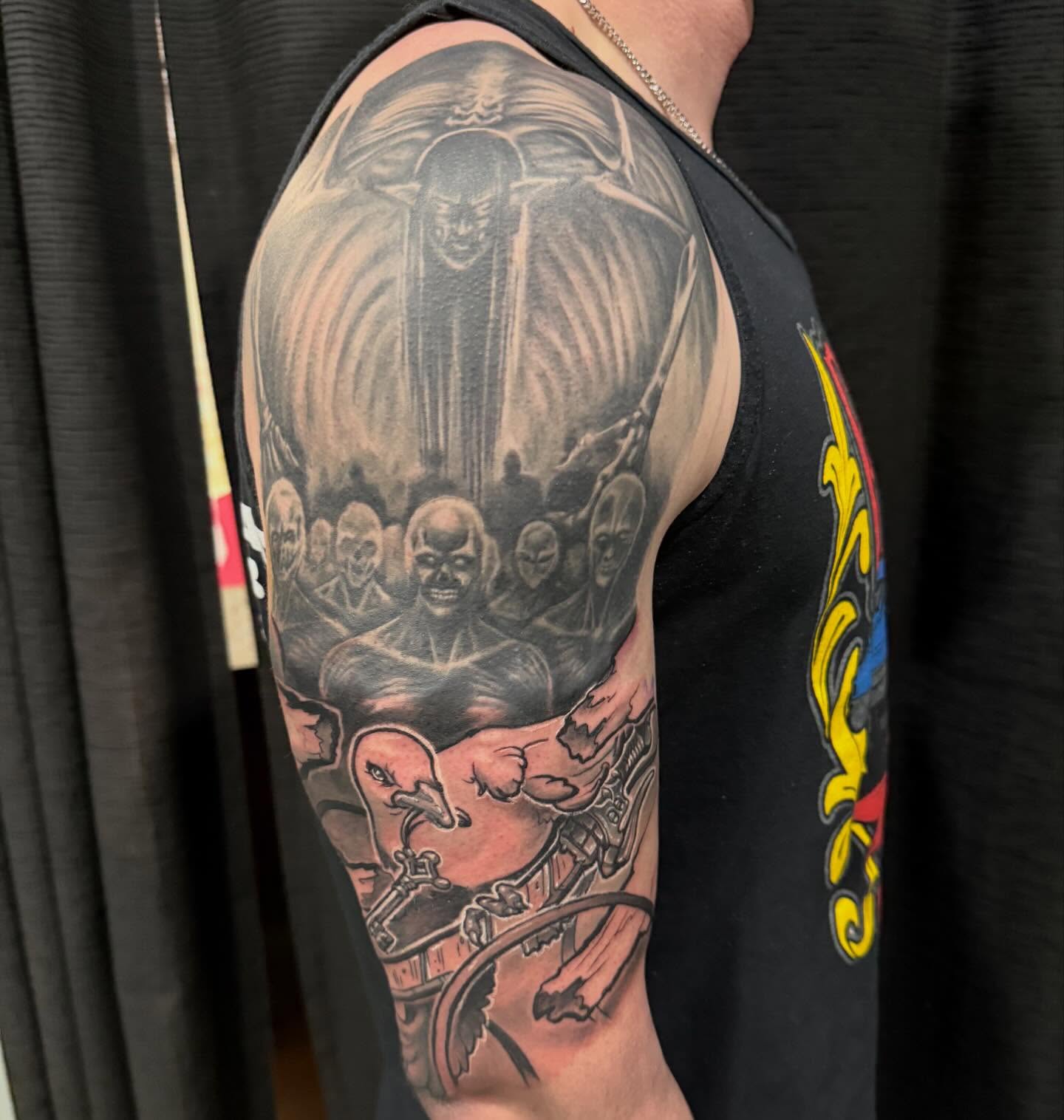 Man with multiple faces American traditional tattoo on the upper arm by Devon Beyer, Mission, Kansas
