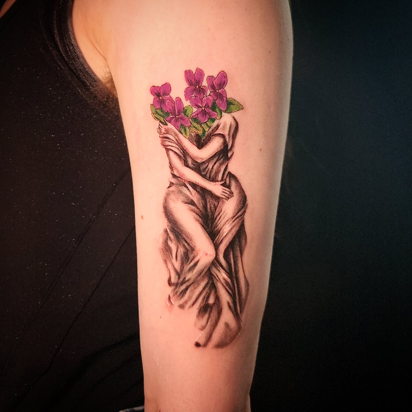 Nude figure with flowers realism tattoo on the forearm by Fia Lopez