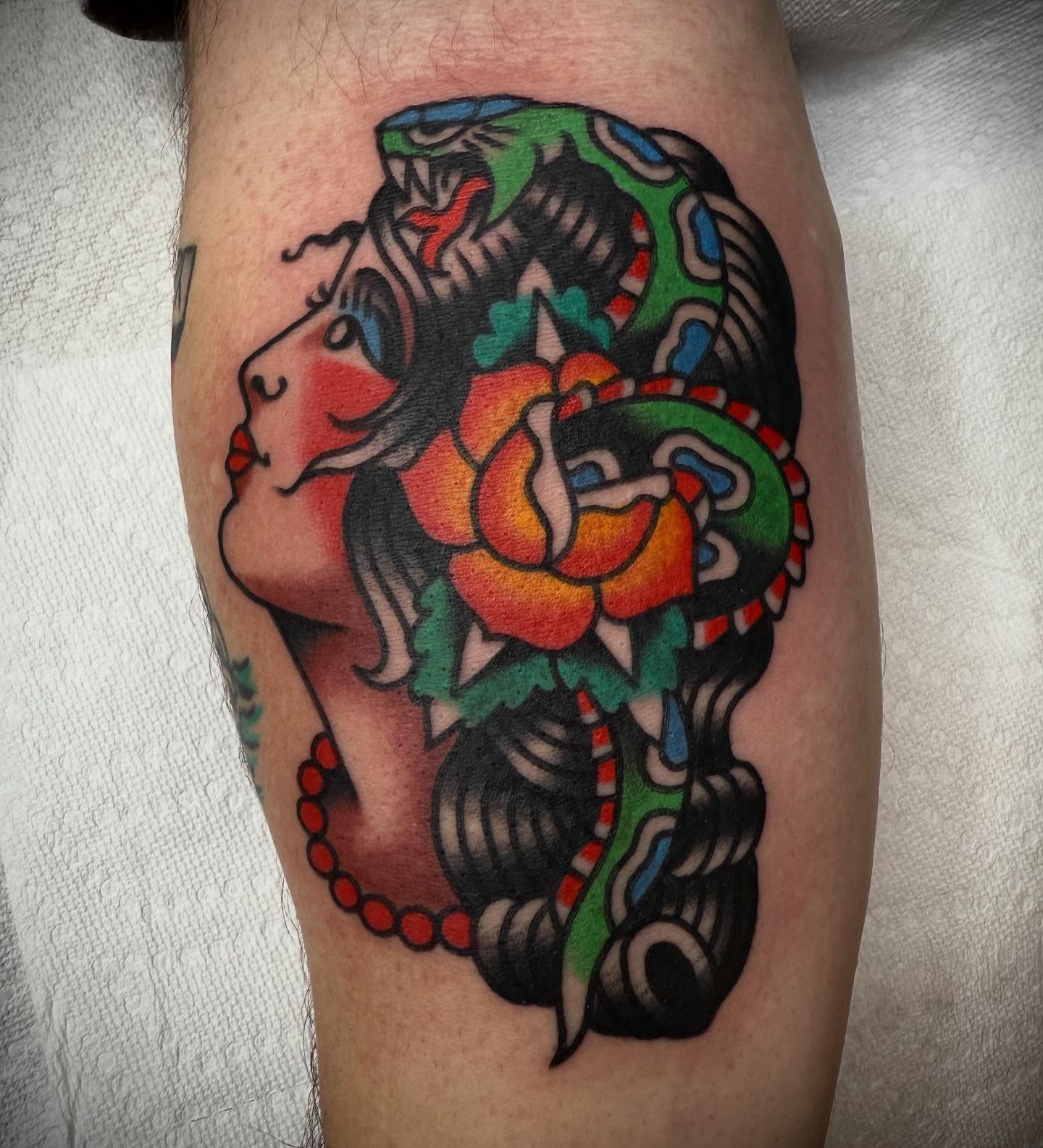 Snake and rose American traditional tattoo on the thigh by Tristan Bradshaw