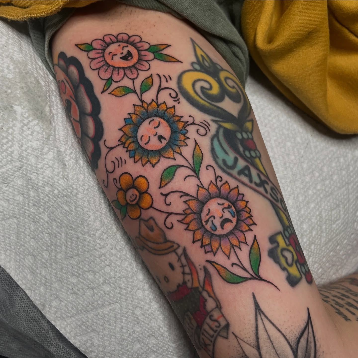 Sunflowers and faces American traditional tattoo on the forearm by Timmy