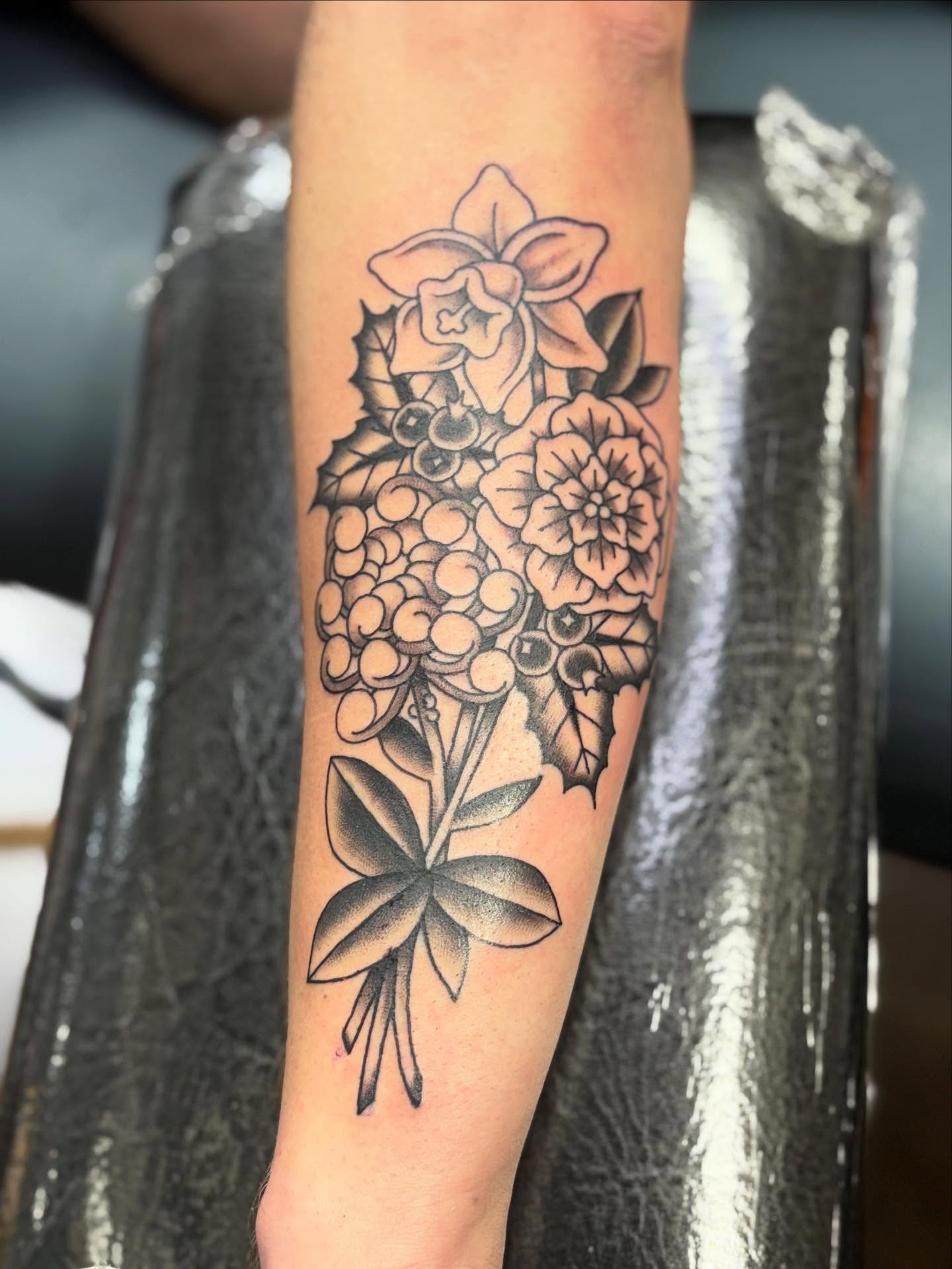 Floral bouquet black and grey tattoo on the forearm by Jakob Ristau, Kansas City, Missouri
